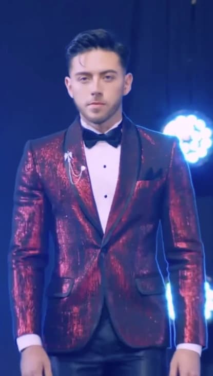 Josué Portillo en el escenario con saco rojo de lentejuelas